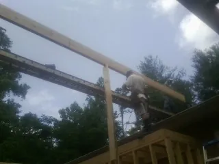 Carpenter setting a ridge beam over a new addition frame — Ice Dam Removal by Roofing Brothers in Alpine